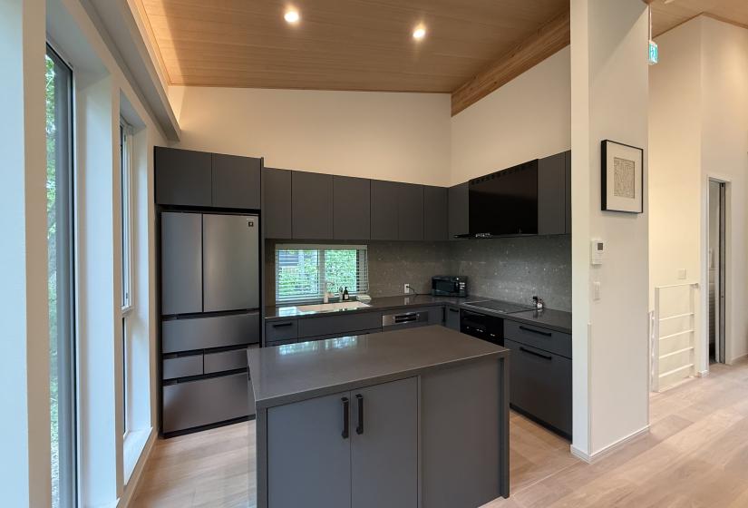 A kitchen with fridge and bench