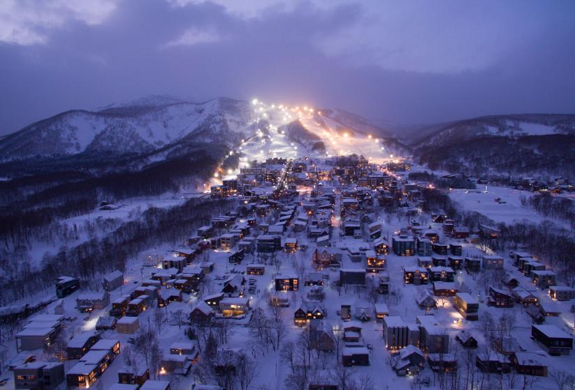 Hirafu Village has the widest range of accommodation and incredible night skiing. Hirafu Village at night with a fully lit resort behind