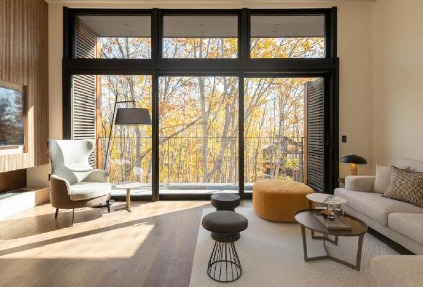 The Fount, located in the Soga area offers beautiful forest views and is a short drive from Niseko Village A lounge suite with autumn leaves on trees in the back ground