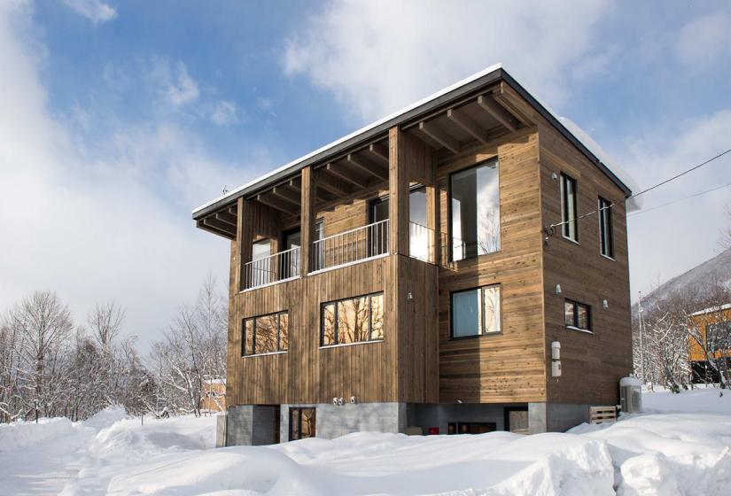 A two story wooden house in the snow
