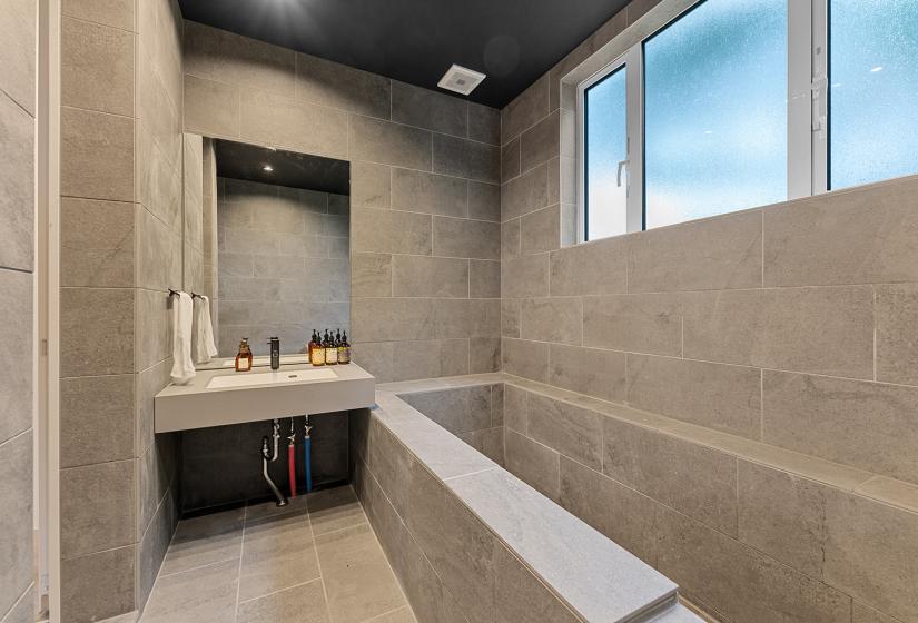 A grey slate bathroom with large bath