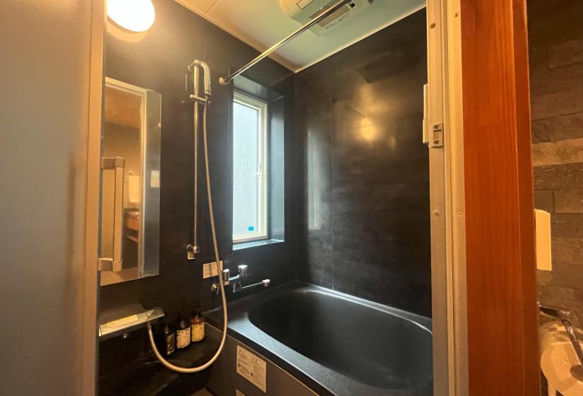 Japanese style bathroom with deep soaking tub and wooden accents at Zangetsu Niseko holiday rental