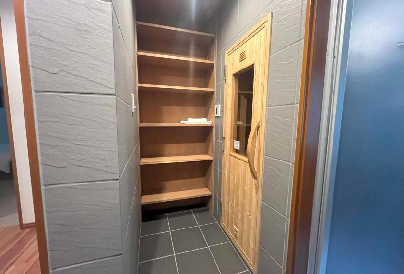 Wooden sauna entrance with built-in storage shelving at Zangetsu Niseko holiday rental