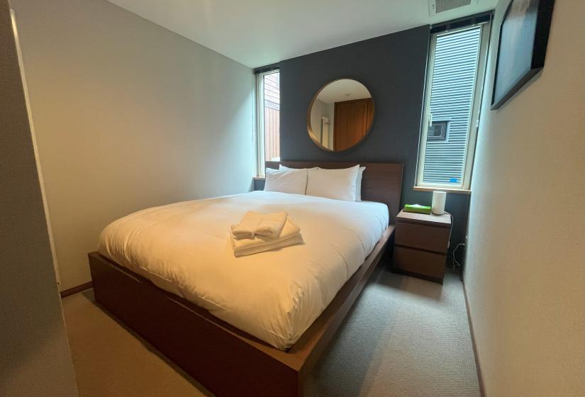 Modern master bedroom with double bed and mountain view window at Zangetsu Niseko holiday rental