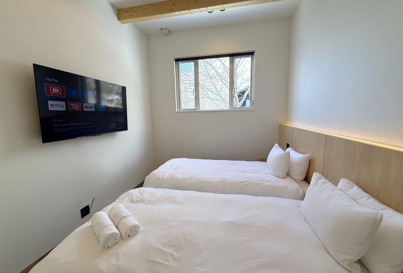 Two single beds below a window