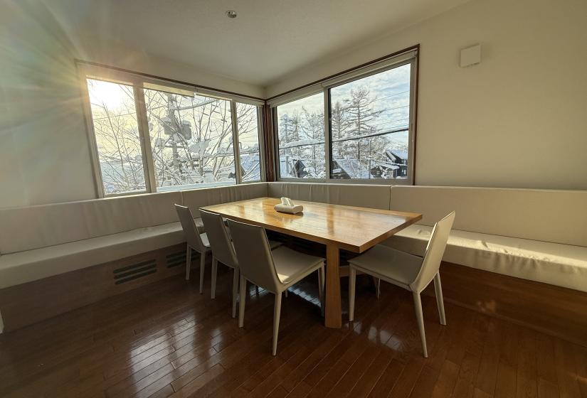 A dining table with sun in window to the left