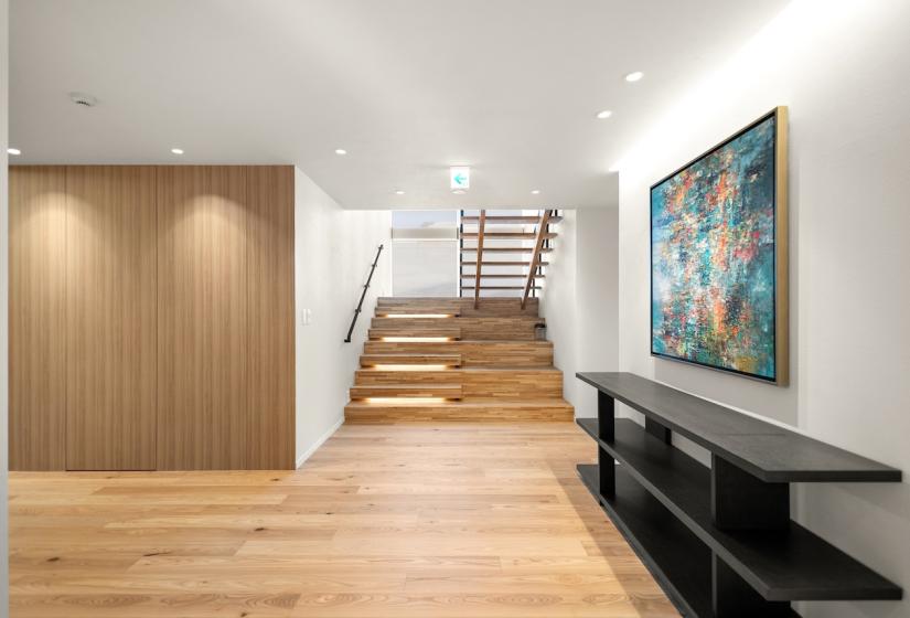 A picture on the wall to the right and stairway at the back