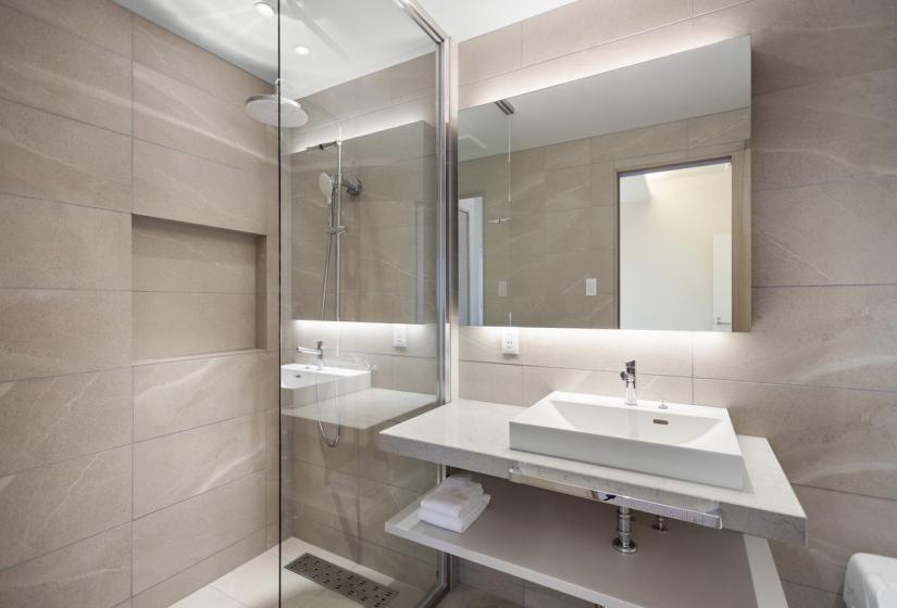 A bathroom basin and shower behind