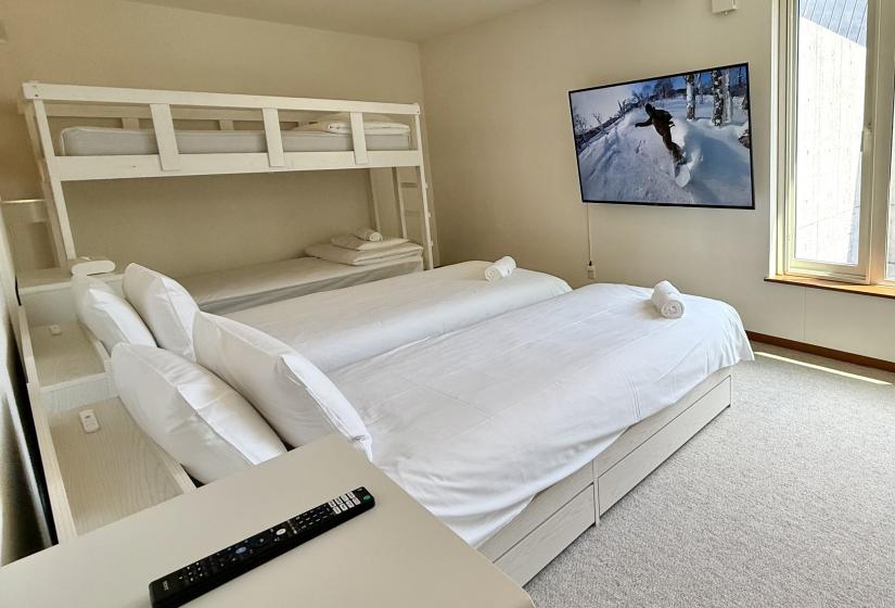 Two made up single beds with bunk bed behind
