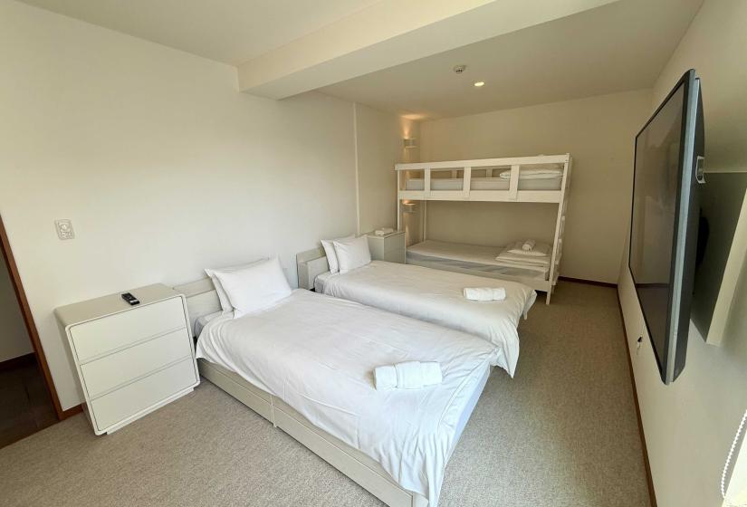 Two made up single beds with bunk to the right