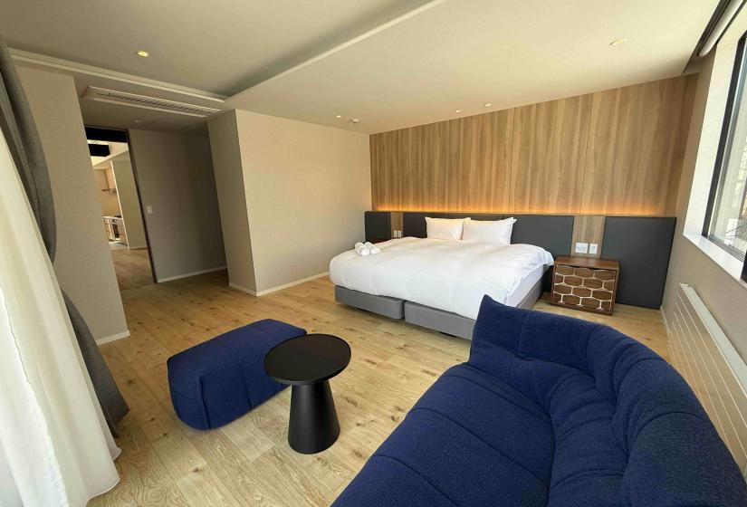 A double bed with blue couch in front