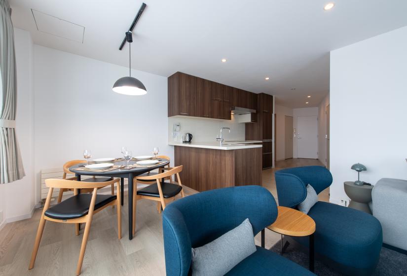 A blue lounge suite with round dining table behind