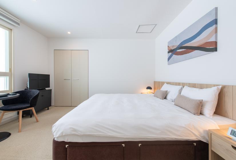A made up double bed with white duvet