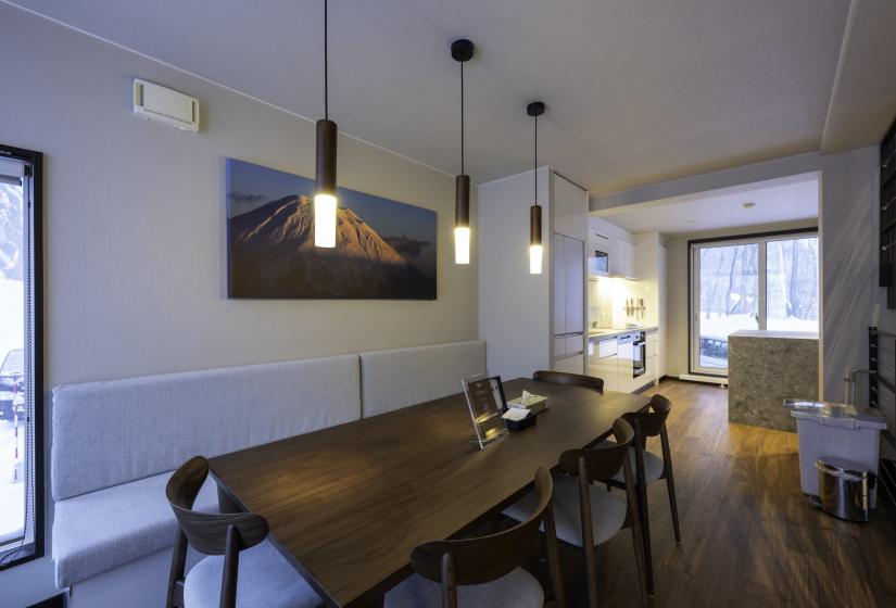 A dining table with pendant lighting above