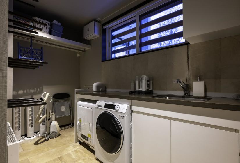 A laundry with bench and washing machibe