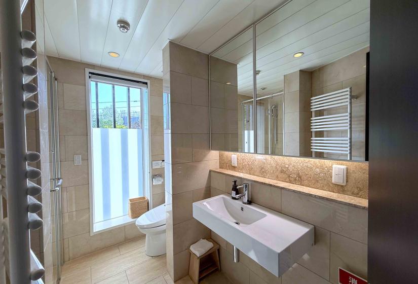 A tiled bathroom with toilet and sink