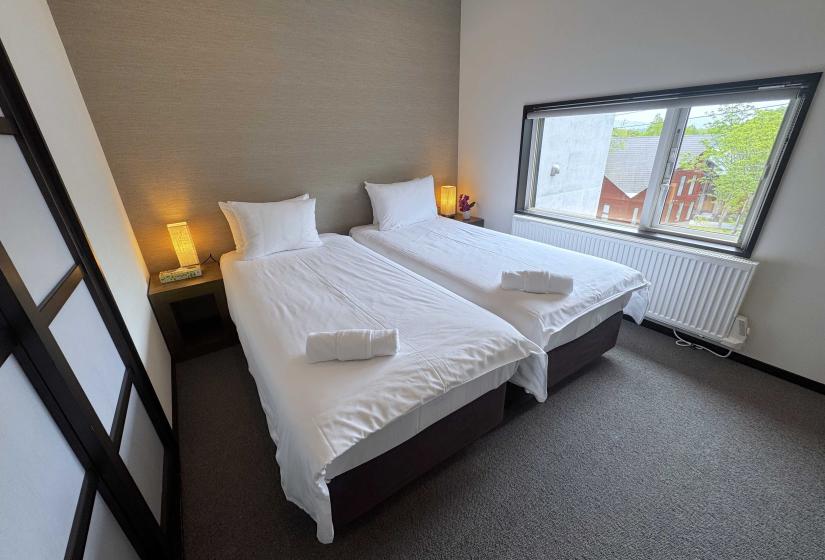 Two made up double beds with shoji doors to the left