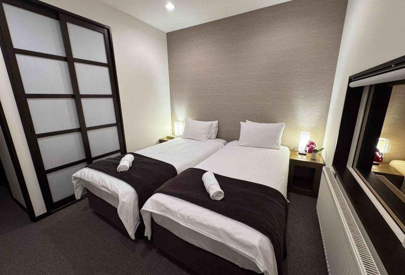 Two made up single beds with shoji doors top left