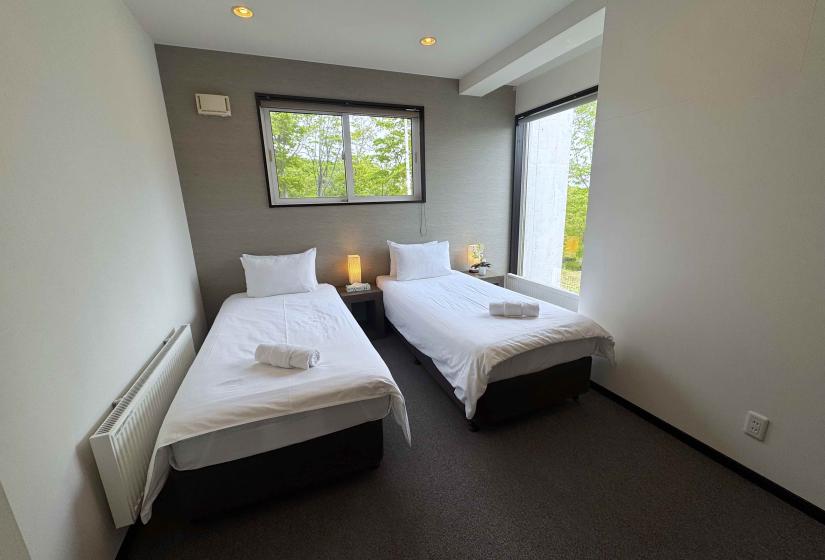 two single beds with towels at their foot