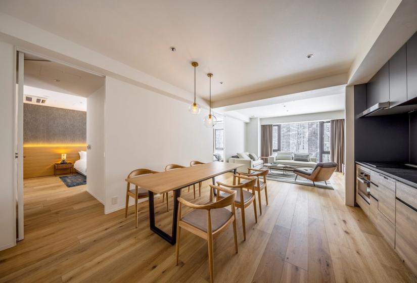 A table and chairs with bathroom behind