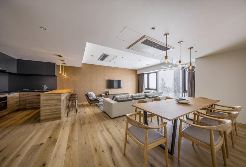 A dining table and lounge area behind