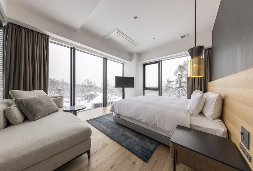 A made up double bed with TV behind