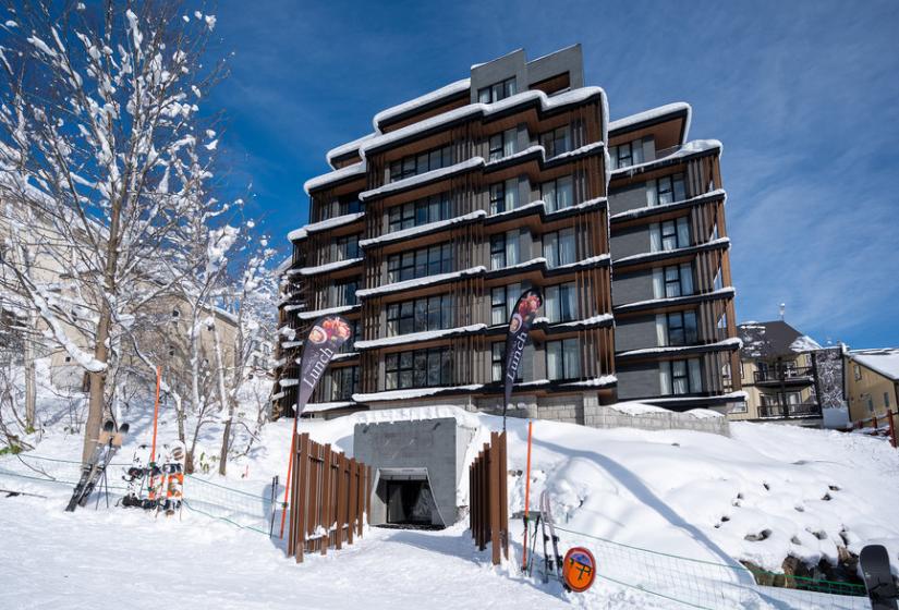 A multi story black hotel in the snow