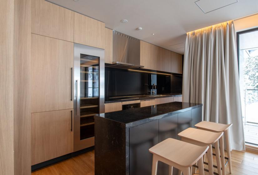 A black kitchen with wooden stools