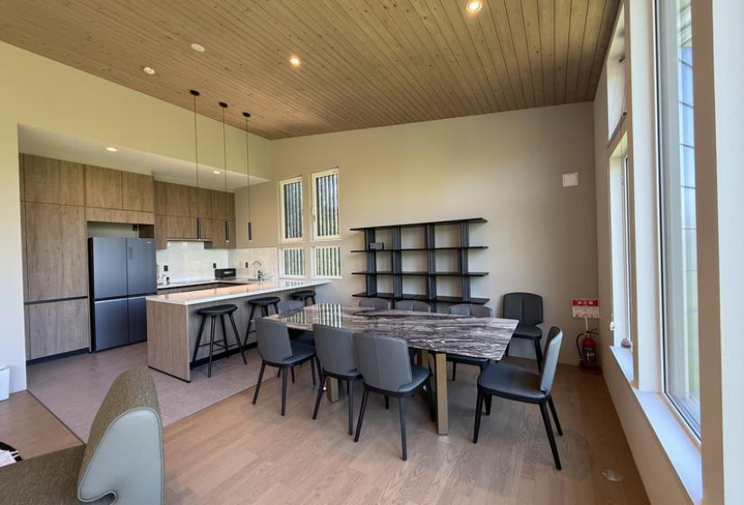 A dining table and kitchen behind