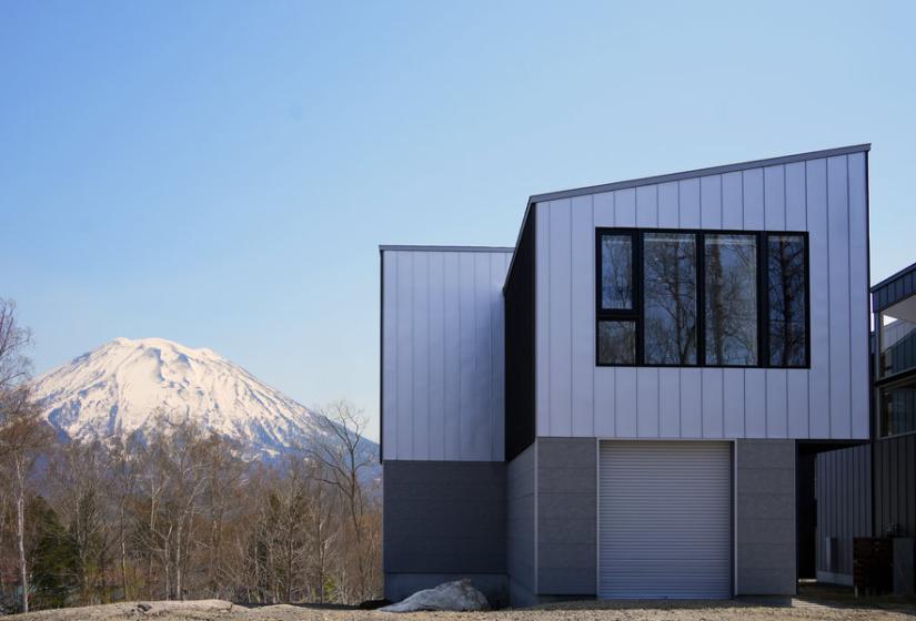 A two storu house exterior with Mt Yotei behind