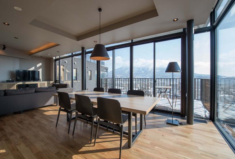 a ding table with 6 chairs and windows behind