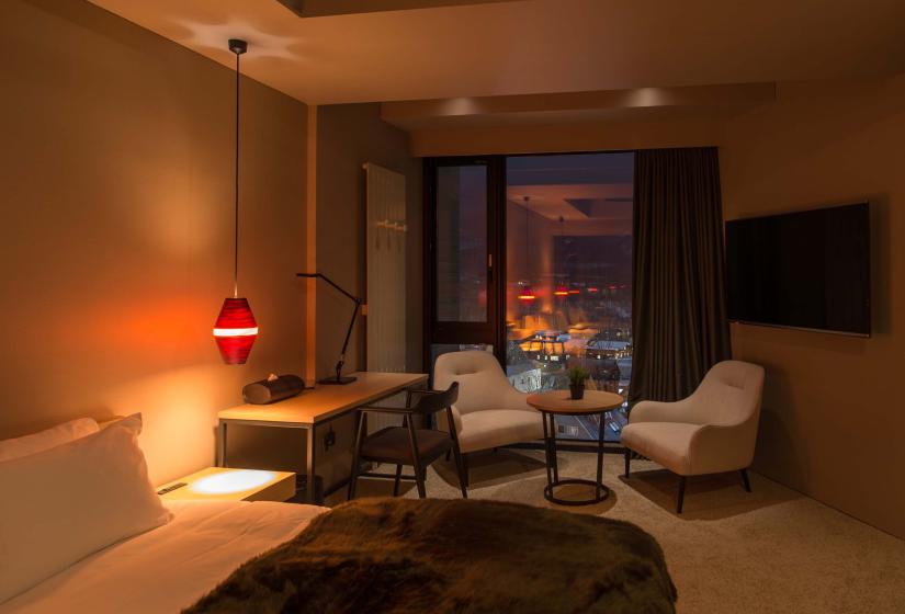 A bedroom at night with two white chairs