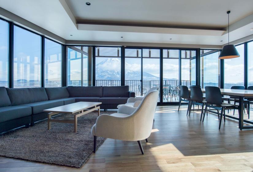 A spacious lounge and dining area with mountain views behind