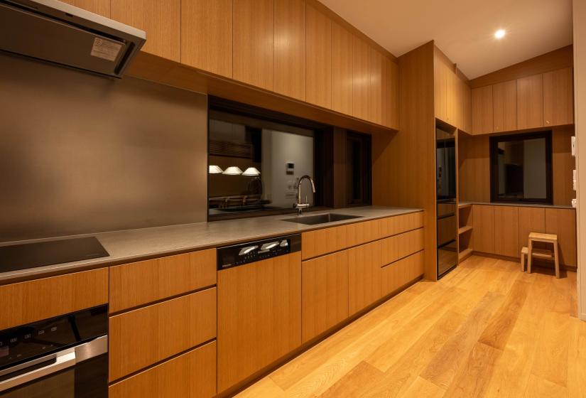 Oak galley kitchen with Miele appliances and window over the sink, Setsuei Niseko