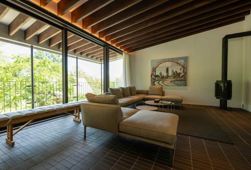 Setsuei Niseko lounge with timber beams, sectional sofa and wood stove