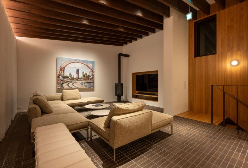 Evening lounge with sofa, wood stove, artwork and TV nook, Setsuei Niseko