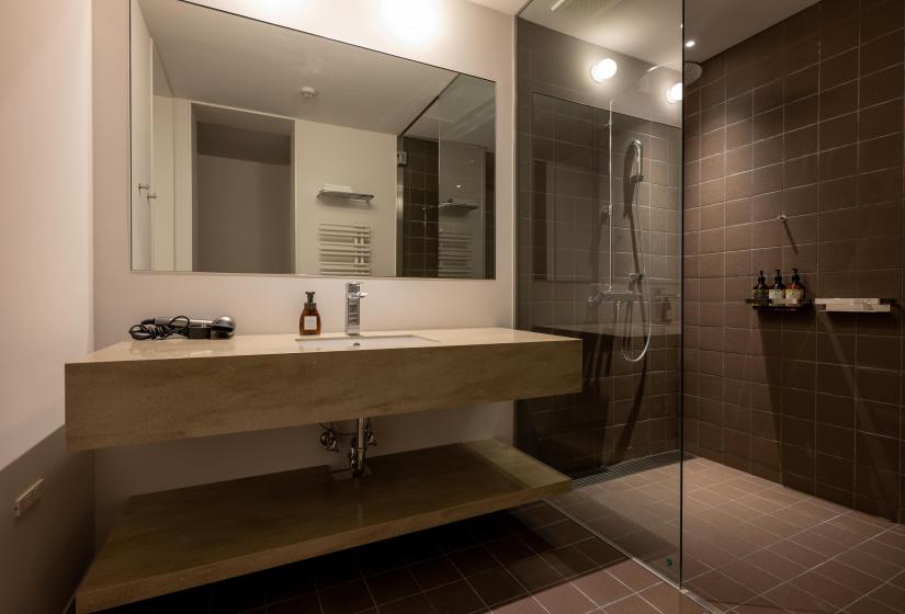 A sink and grey tile shower
