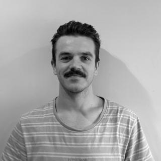 A man with a moustache smiling
